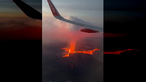 Plane passengers film Iceland volcano lava