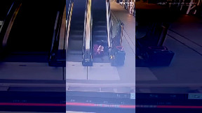 Woman with kid escalator fall