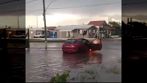 Car catches fire on flooded road