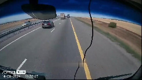 Car almost squashed between trucks